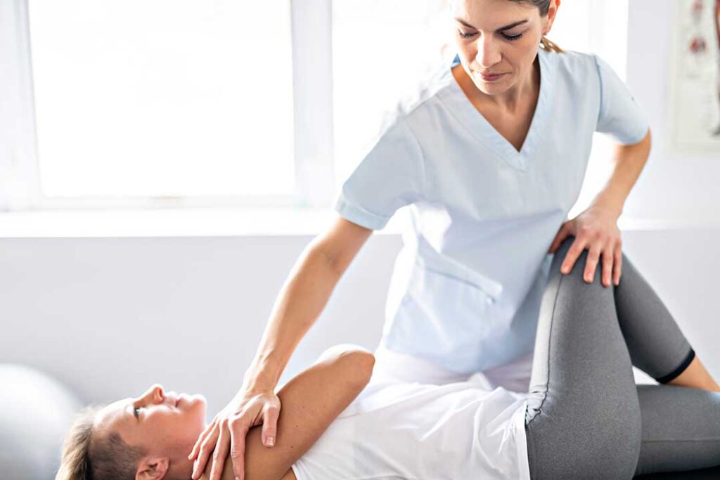 A chiropractor gently adjusts an adult patient's back in a calm clinical setting.