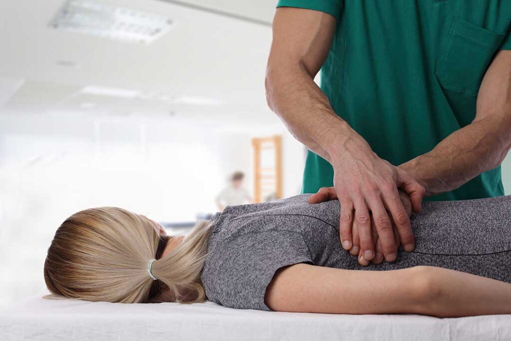 Person gently turning their neck while seated near a window, with a cervical spine illustration nearby.