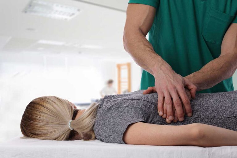 Person gently turning their neck while seated near a window, with a cervical spine illustration nearby.